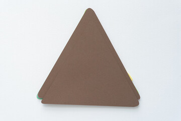 isolated pile of brown paper triangles on blank paper