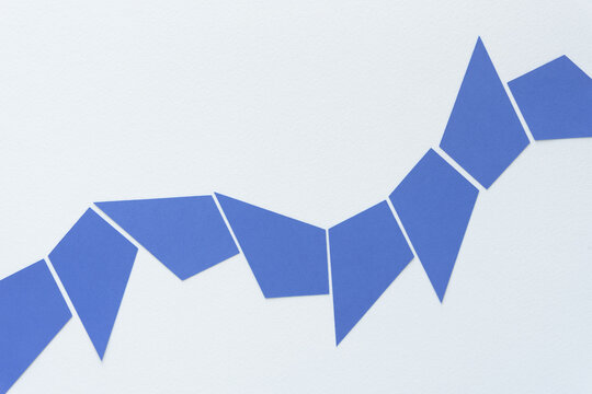 segmented blue line composed of kite or diamond shaped paper pieces and arranged on blank paper