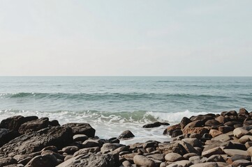 Calm ocean waves lapping rocky shore, peaceful sky