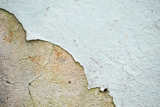Image horizontal de una pared de cemento con la pintura cayendose color blanco vieja 