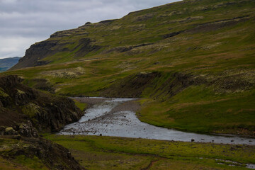 Fototapeta premium Icelandic River Flowing Through Rocky Green Valley