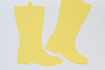 machine-cut light pale yellow boot shapes on blank paper