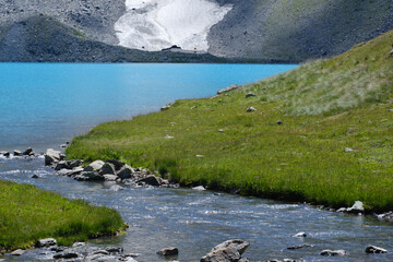 a stunning mountain river flowing out of a turquoise lake