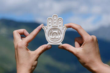 female hands holding yoga symbol