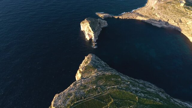 Epic aerial drone view of  dramatic cliff and sea stck at sunset.