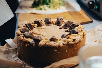 Caramel and nut kinder bueno cheesecake being  placed on the kitchen counter.