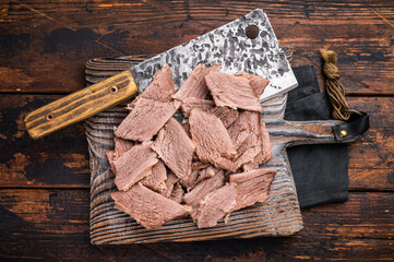 Corned sliced beef meat on wooden cutting board. wooden background. top view