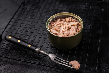 Convenient tinned tuna fillet, perfect for quick meals and packed with protein for a healthy lifestyle. black background. top view
