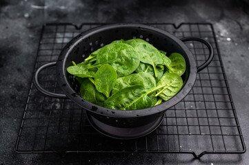 Nutrient rich fresh spinach leaves, perfect for adding flavor and health benefits to your meals and snacks. black background. top view