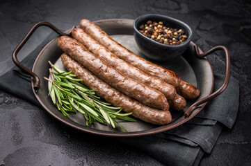 Juicy grilled sausage sizzling on the barbecue, perfect for summer cookouts and outdoor gatherings. black background. top view