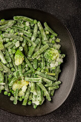 Frozen green vegetables green peas, broccoli, string beans, kohlrabi kale tasty snack fresh food background on the table rustic food top view copy space keto and paleo diet vegan and vegetarian food