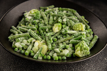 Frozen green vegetables green peas, broccoli, string beans, kohlrabi kale tasty snack fresh food background on the table rustic food top view copy space keto and paleo diet vegan and vegetarian food