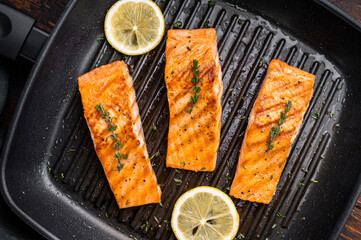 Pan fried salmon fillet steaks with thyme and lemon, fresh fish. wooden background. top view