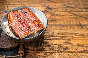 Unagi don or Japanese grilled eel rice in a bowl. wooden background. top view