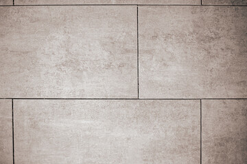 Fototapeta premium Close-up of uniformly laid large format ceramic tiles with straight lines without grout