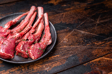 Raw lamb chop cutlets, fresh mutton meat for steaks with herbs. wooden background. top view