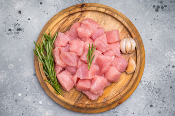 Diced raw turkey breast fillets, sliced poultry meat. grey background. top view
