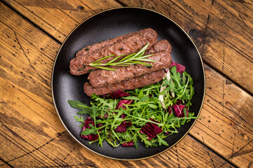 Balkan BBQ roast Cevapcici Sausage, roasted Cevapi from mince beef and pork meat. wooden background. top view