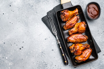 Juicy barbecue chicken wings, perfectly grilled and glazed, ideal for your next summer cookout or party. grey background. top view