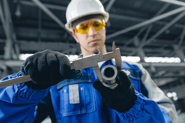 Technical Control concept, Male turner engineer measuring components in industrial setting with precision tools