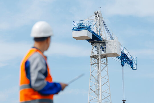 Industrial engineer in white hard hat and blue uniform use tablet. Concept inspector work in container terminal or cargo logistic center