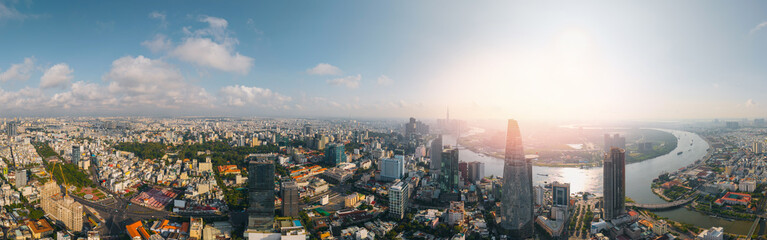 Fototapeta premium Panorama Ho Chi Minh City skyline and skyscrapers on Saigon river. Financial business center at downtown sunset time.