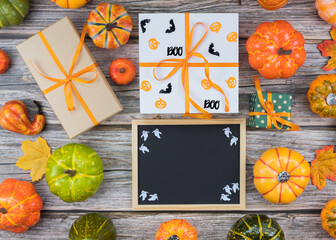 Halloween pumpkins and gift boxes with chalkboard top view copy space