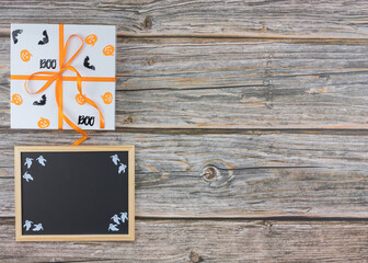 Top view Halloween gift box and chalkboard on wooden table copy space