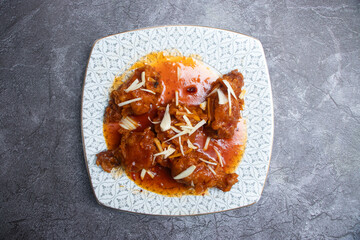 Sweet and Spicy Honey Garlic Chicken Lollipops Garnished with Almond Slivers in plate top view of Asian food