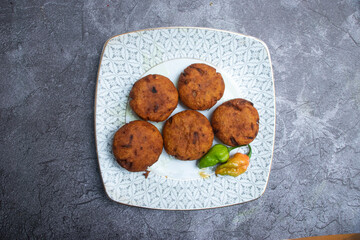Naga Aloo chap or Crispy Lentil Fritters with Hot Peppers in plate top view of A Savory South Asian Snack