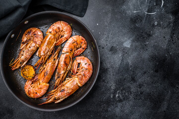 Pan fried red Argentine shrimps, Prawns Langostino Austral with herbs. black background. top view