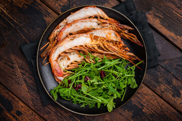 Seafood dinner with  Grilled red Shrimps Prawns Langostino Austral on a plate with salad. wooden background. top view