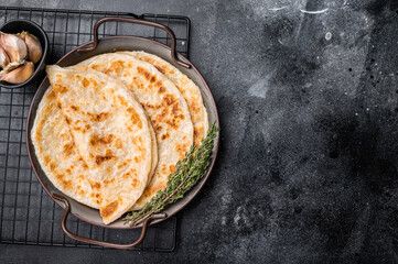Aloo Paratha Indian Potato stuffed Flatbread. black background. top view