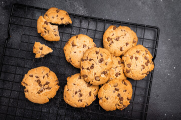 Baked Chocolate chip cookies on steel rack. black background. top view