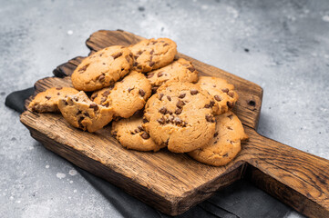 Stack of Chocolate chip cookies on wooden board. grey background. top view
