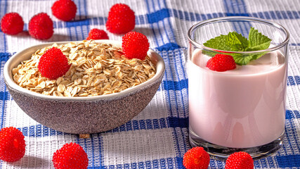 Healthy breakfast concept featuring yogurt, oatmeal flakes, and tibetan raspberry berries