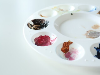 Close-up view of plastic artist palette containing vibrant, mixed paints on a clean surface, symbolizing creativity and artistic expression. Ideal for projects related to painting, arts, or creativity
