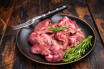 Raw chicken liver, featuring a glossy sheen and rich hue. A versatile ingredient that brings bold flavors to any culinary creation. wooden background. top view