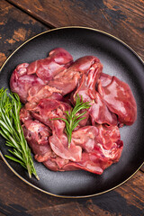 Raw chicken liver, featuring a glossy sheen and rich hue. A versatile ingredient that brings bold flavors to any culinary creation. wooden background. top view