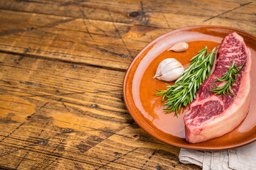 Raw sirloin beef steak, featuring a vibrant hue and well defined grain. wooden background. top view