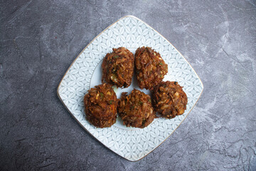 Vegetable Pakora, a popular deep fried fritters in plate top view of South Asian snack