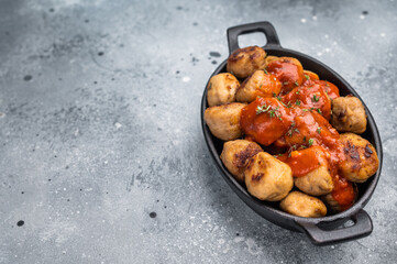 Roast meatballs served with tomato sauce. A classic comfort food in a skillet. grey background. top view