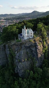 Aerial drone footage of the Pastyrska Stena lookout tower in Decin, Czech Republic. Scenic panoramic views of the historic tower, sandstone cliffs, and the Elbe River surrounded by nature 