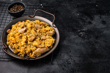 Arabic national rice food pilaf or plov, cooked with fried lamb and beef meat. black background. top view