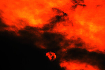 Sun partially obscured by clouds