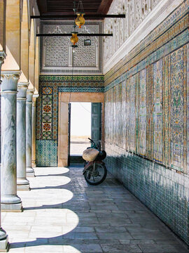 A motorbike parked beneath historic wall in the  corridor of Dar Ben Abdallah, Tunis &mdash; where two wheels meet centuries  and still air waits for motion.