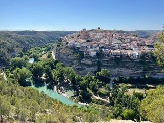 Panoramic view of Jorquera on the hill above blue river. Charming Spanish village built into the cliffs of a dramatic canyon, Castilla-La Mancha, Spain. 25 May 2025