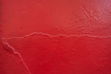Pared roja con textura desgastada y grietas visibles