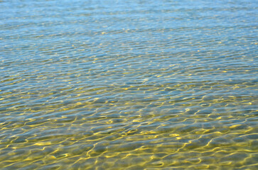 Clean water of the lake in sunny day. and light  waves . Blue and yellow colors lake water surface.