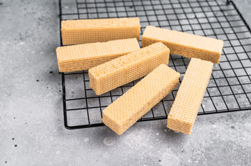 Dry Wafer stick biscuits with vanilla cream on a rack. grey background. top view